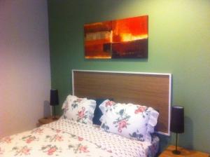 日惹攀查德薇宾馆的卧室配有一张床,墙上挂有绘画作品
