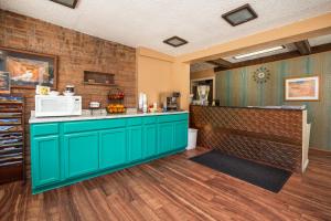 卡纳布艾肯斯旅馆的一间厨房,配有绿色的橱柜和微波炉