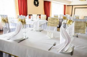 卡拉甘达祖穆拉特酒店的一张带白色桌布、餐巾纸和餐具的桌子