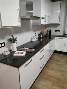 VimianzoCasa da Xastra的厨房配有白色橱柜和黑色台面