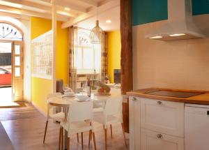 雷凯蒂奥TALA FLAT的厨房设有黄色的墙壁和桌椅