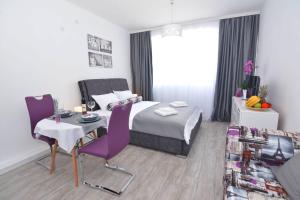蒂瓦特Small Oasis Apartment的酒店客房带一张床、一张桌子和椅子