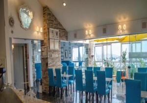 利马Hotel Vila Santa的餐厅设有蓝色的椅子和桌子以及窗户。