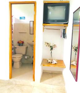 圣玛尔塔CasaHotelMarly的一间带卫生间的浴室和墙上的电视