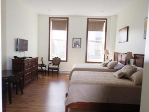 夏洛特顿Water Suites的一间卧室配有两张床、一张桌子和两个窗户。