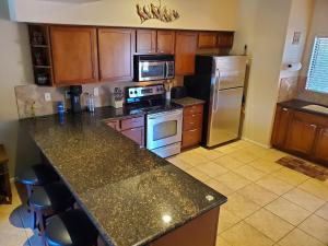 塞多纳Red Rock Luxury的厨房配有花岗岩台面和冰箱