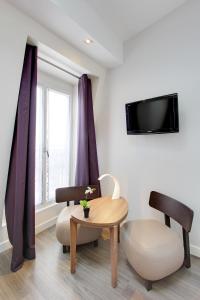 巴黎阿朗布拉酒店的客厅配有桌子和椅子