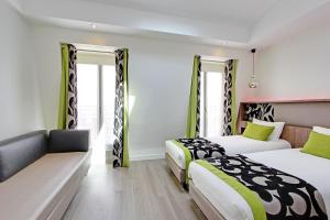 巴黎阿朗布拉酒店的酒店客房,设有两张床和一张沙发