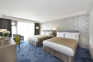 高雄高雄福容大饭店的酒店客房配有两张床和一张书桌