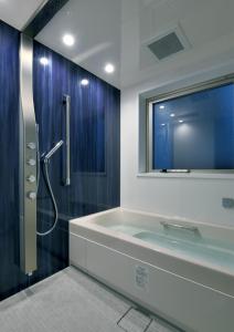 札幌Randor Hotel Sapporo Suites的一间带浴缸和淋浴的浴室,并设有一个窗户