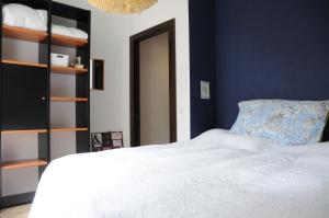 蓬泰特雷萨Acquachiara的卧室配有白色的床和蓝色的墙壁