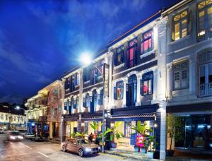 新加坡Hotel Soloha at Chinatown的夜间在街上停车的建筑物
