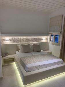 阿斯提帕莱亚镇Astra Studios的白色卧室配有一张带灯的白色大床