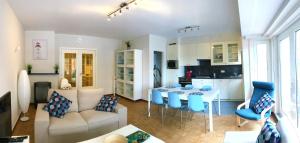 尼乌波特Duinenblik 2的客厅以及带桌子和蓝色椅子的厨房。