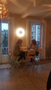 桑坦德Hostel Royalty ALBERGUE的两个女人坐在房间里桌子上