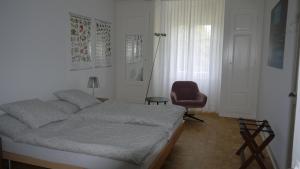 伯尔尼Habsburg B&B的一间卧室配有一张床和一张红色椅子