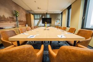 莱顿Fletcher Wellness-Hotel Leiden的大型会议室,配有大桌子和椅子