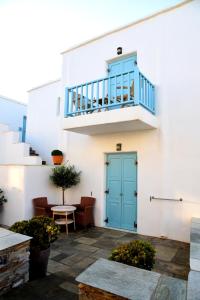 基斯诺斯Hotel Messaria的白色的建筑,设有蓝色的门和楼梯