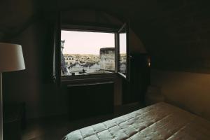马泰拉艾尔伯格德希迪雷酒店的一间卧室设有窗户,享有城市美景