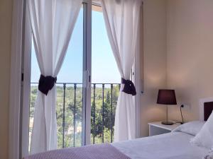 拉梅特拉·德·玛尔Apartamento exterior en La Ametlla de Mar的卧室设有大窗户和白色窗帘