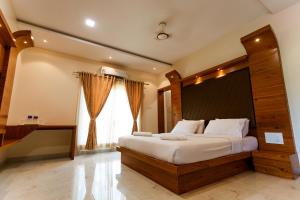 哥印拜陀SR Jungle Resort的一间卧室设有一张大床和一个大窗户