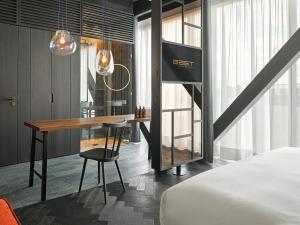 汉堡east Hotel Hamburg的酒店客房配有书桌和床。
