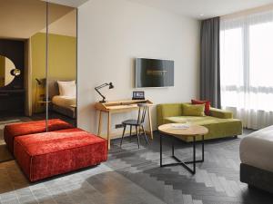 汉堡east Hotel Hamburg的酒店客房配有床、沙发和桌子。
