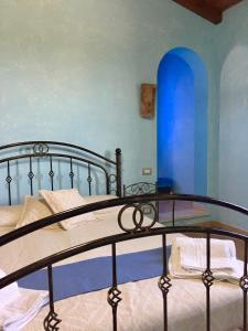 San Priamo卡鲁比旅馆的一间卧室配有一张蓝色墙壁的床