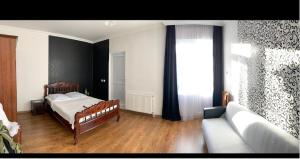 泰拉维guest house Telavi XXI的一间卧室配有一张床、一张沙发和一个窗口