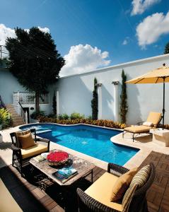 梅里达阿祖尔历史纪念碑酒店的一个带桌椅的庭院和一个游泳池