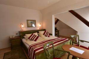 玛丽亚温泉圣格尔格葛拉尼酒店的卧室配有一张床和一张桌子及椅子