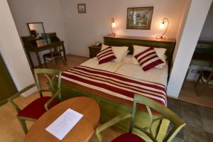 玛丽亚温泉圣格尔格葛拉尼酒店的一间卧室配有一张带两把椅子和两张桌子的床。