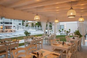 卡尼奥提Laguna Resort Boutique Hotel的餐厅配有白色的桌椅和灯光