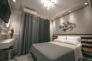 米克诺斯城影城品牌酒店的一间卧室配有一张床、一个水槽和一台电视