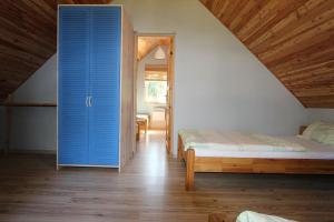 波别罗沃domki letniskowe Gnieźnieńska Pobierowo的一间卧室配有一张床和一个蓝色的门