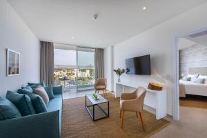 帕福斯莱昂纳多广场塞浦路斯马里斯海滩酒店及Spa的酒店客房设有沙发、床和电视。