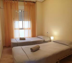 瓜尔达马尔·德尔·塞古拉Apartamento Cervantes的带窗户的客房内的三张床
