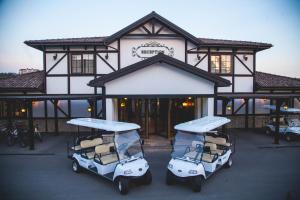 沙马基萨基特古尔 - 静湖度假村的两辆高尔夫球车停在大楼前