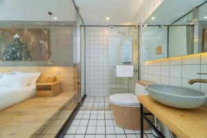 德清莫干山品后屋大酒店的一间带水槽和卫生间的浴室以及一张床