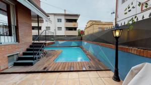 班约莱斯HOUSE OF JOY , CASA EN BANYOLES的一个带木甲板和街灯的游泳池