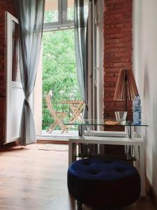 克拉科夫Topolove Rooms & Apartments的玻璃桌和窗前的蓝色箱形箱