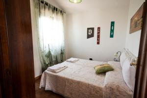 卡萨拉诺Le more Holiday Home的一间卧室配有一张带毯子的床和窗户