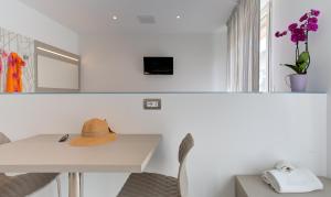 里米尼Alloggio Nella的一间白色的房间,上面有一张桌子和一顶帽子