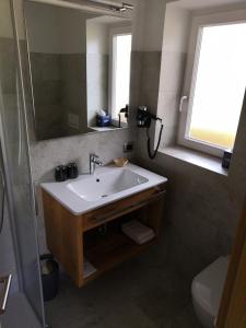 塞尔瓦迪加尔代纳山谷加尔尼马特尔霍夫旅馆的一间带水槽、镜子和卫生间的浴室