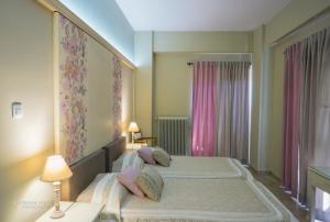 埃尔莫波利斯Ostria的一间卧室配有一张带粉红色窗帘的大床