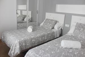 阿尔戈多纳莱斯Be happy Arco的一间卧室配有两张床和镜子
