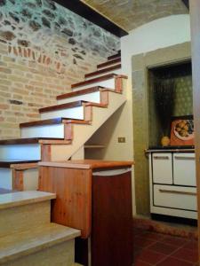 奥温多利Casa Lombardi的楼梯位于厨房,厨房配有柜台和炉灶