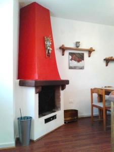 奥温多利Casa Lombardi的客厅设有红色壁炉,配有桌子