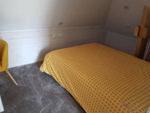 昂热Angers Green Lodge - Yellow Sun Appartement的小卧室配有带橙色棉被的床