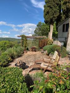 塞尔苏里格La Fontanella Country House的庭院里设有椅子和火坑
